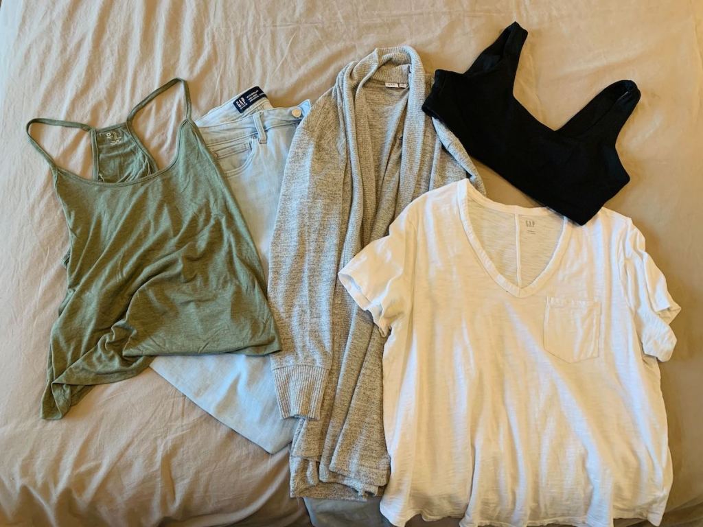 various styles of GAP clothing laying on bed 