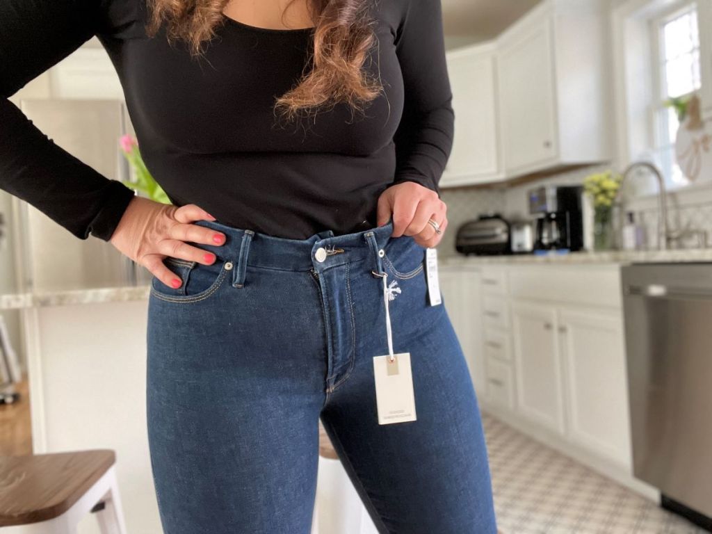 Woman wearing a black shirt and a pair of Good American jeans