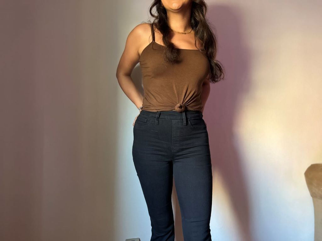 Woman wearing a brown tank top and black jeans