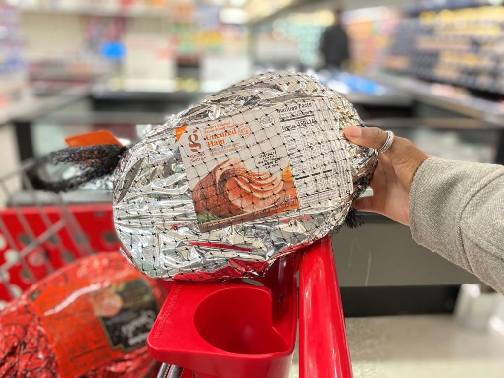 Hand holding a ham on a Target cart
