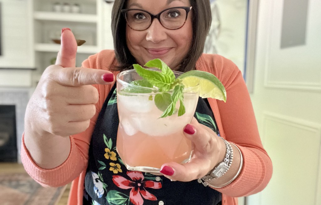 Woman holding a mojito mocktail that tastes like guava and mint