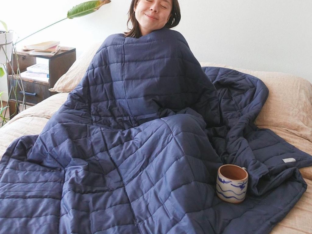 Woman wrapped in a Casper Weighted Blanket in indigo