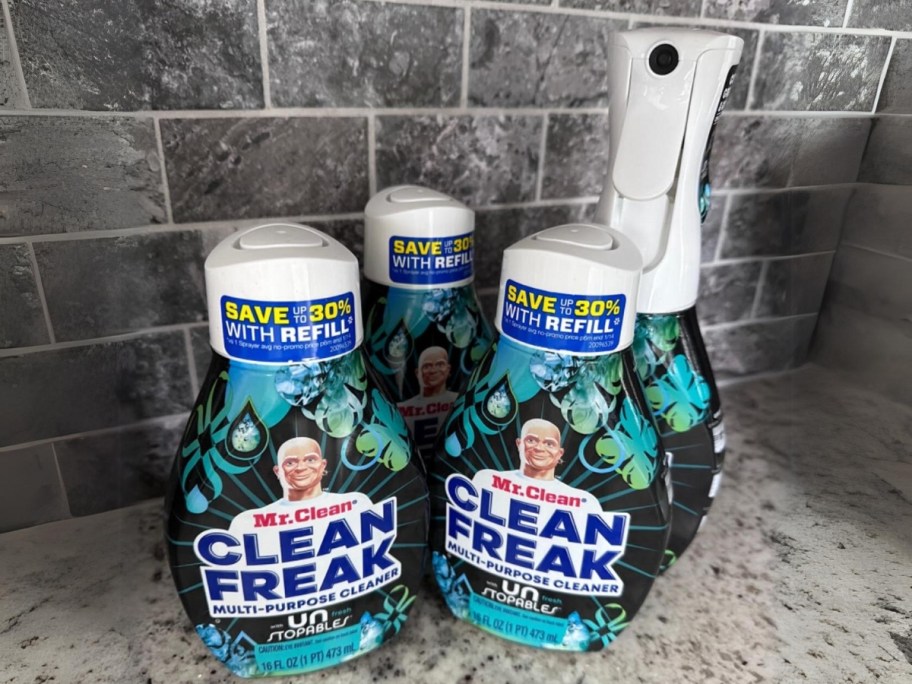 bottle of Mr. Clean Clean Freak cleaning spray with 3 refill bottles on a counter