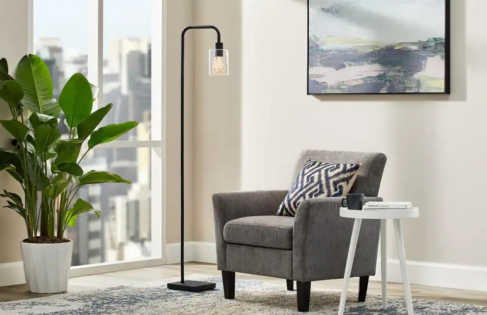 Living room with a plant, tall black lamp, chair, and side table.