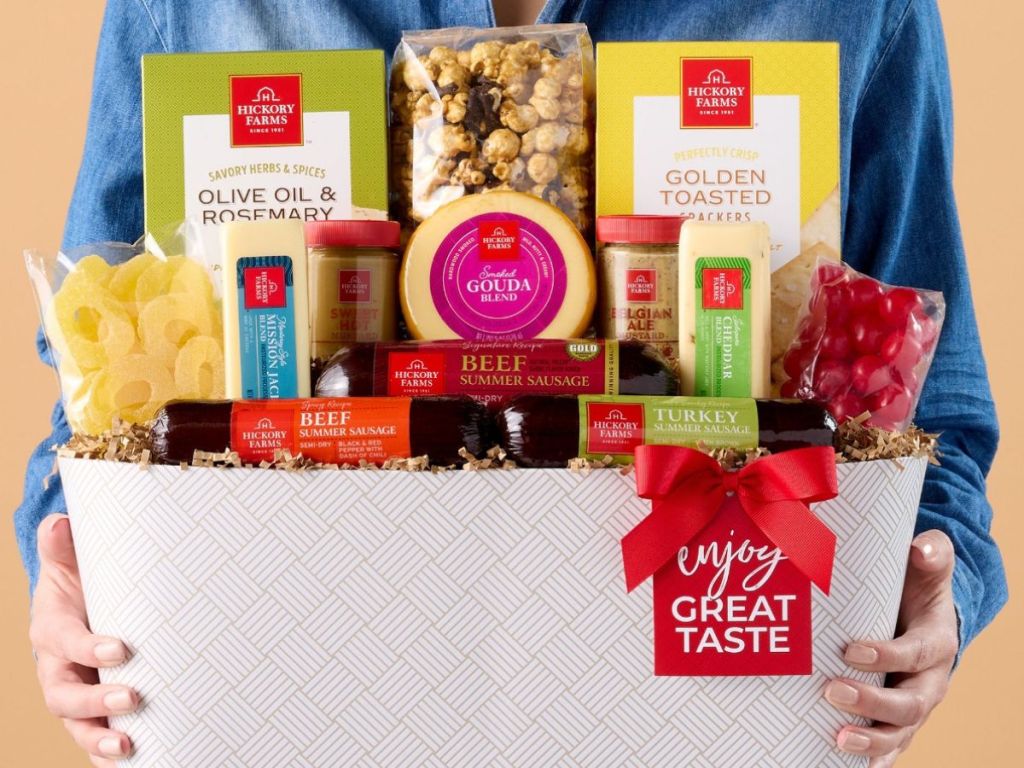 Person holding a large Hickory Farms gift basket