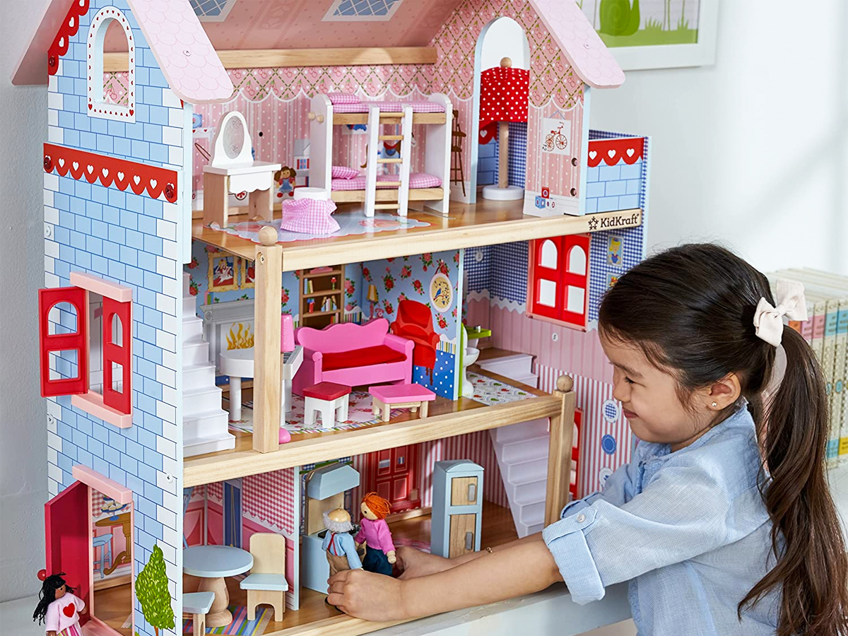girl playing with kidkraft dollhouse