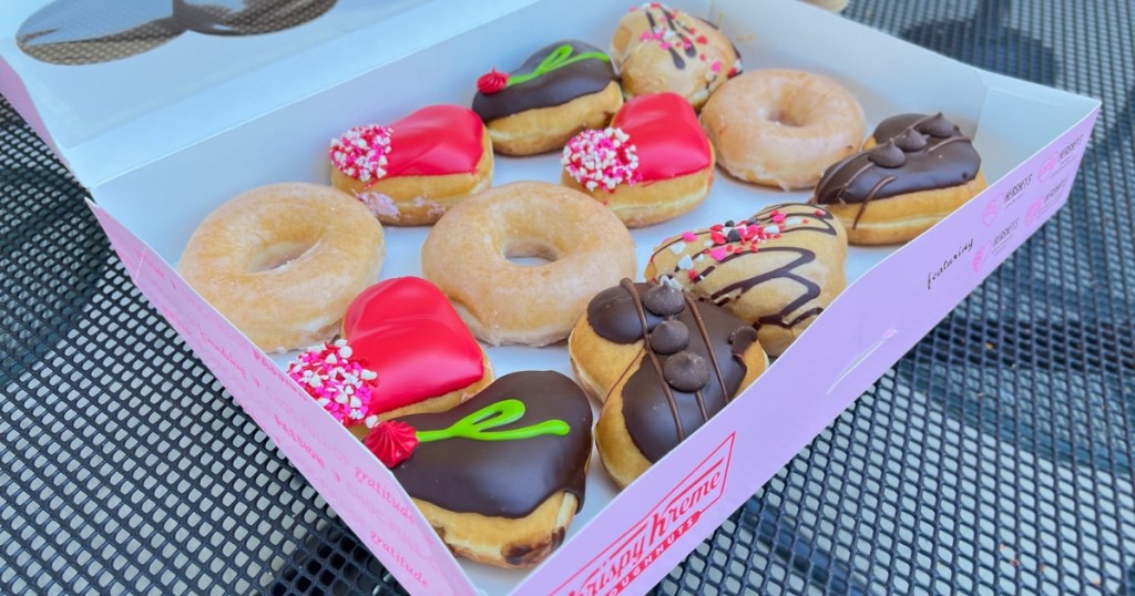 a dozen krispy kreme donuts with heart shapes