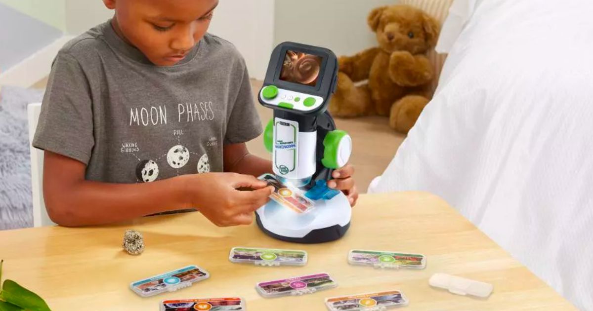 a little boy looking at slides with the LeapFrog Magic adventures microscope and slides