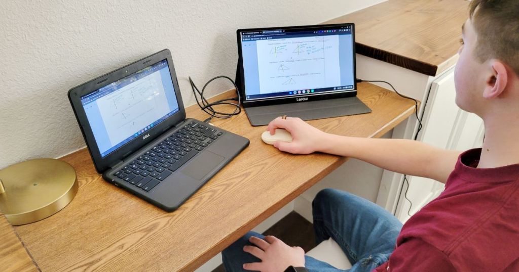 boy looking at laptop with extra monitor connected
