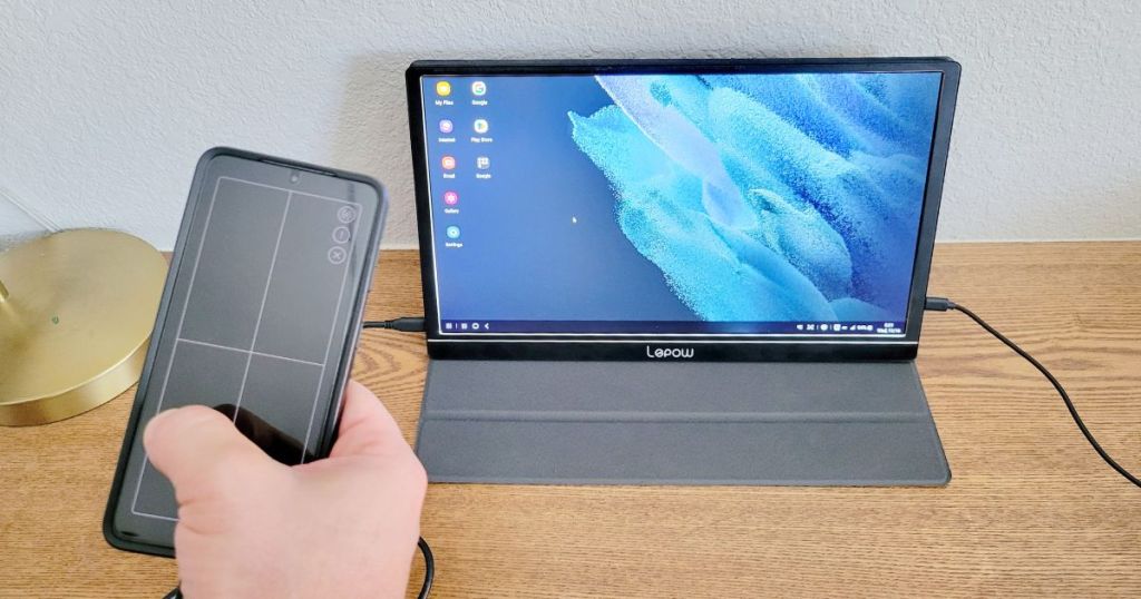 Portable monitor and someone holding a phone next to it