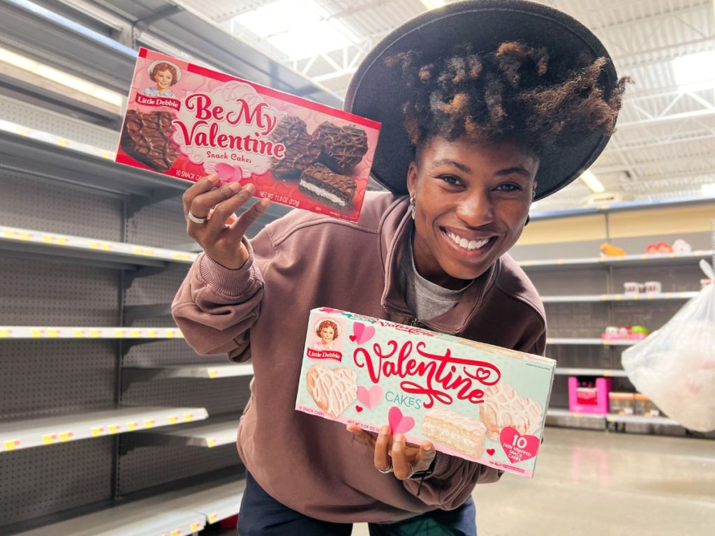 A woman holding 2 boxes of Little Debbie Valentine Treats