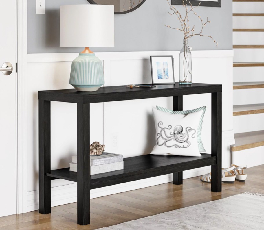 black console table with lamp and picture frame on top
