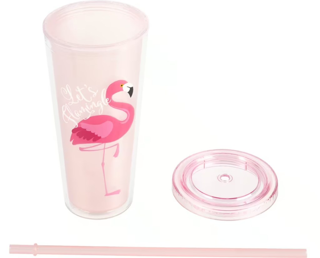 Rosafarbener Becher mit einem Flamingo darauf und dem Deckel daneben mit dem Strohhalm darunter