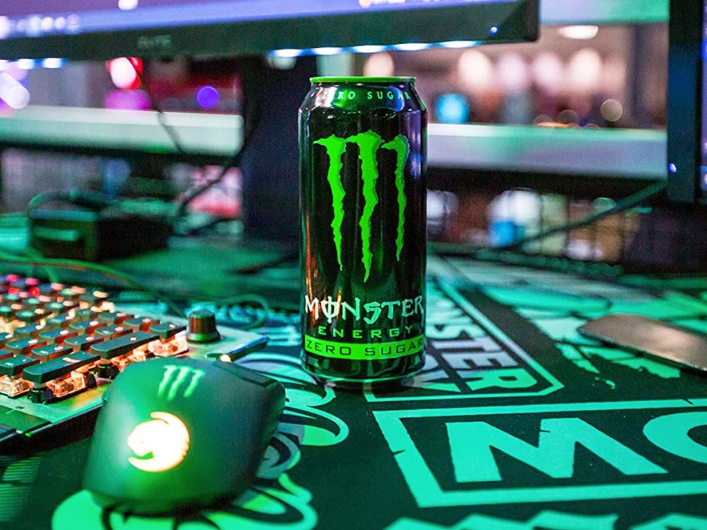 can of monster energy near computer and keyboaard