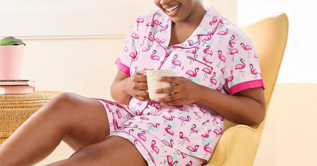 woman drinking coffee wearing Muk Luks Pajamas with flamingo print on them