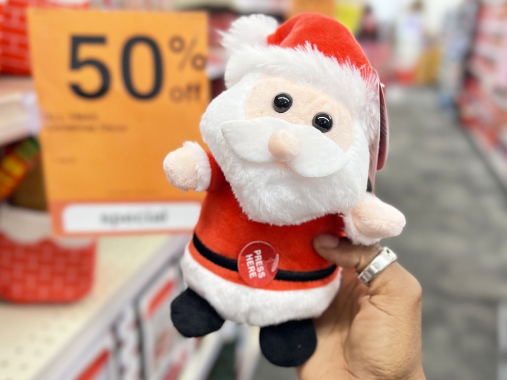hand holding up a musical santa plush