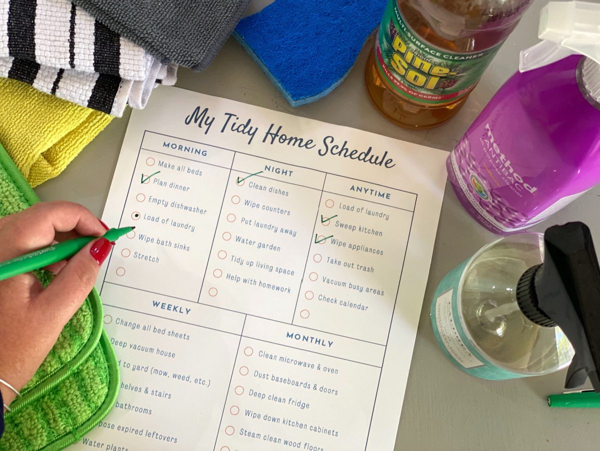 person using a free cleaning schedule printout which acts as a declutter your home checklist 