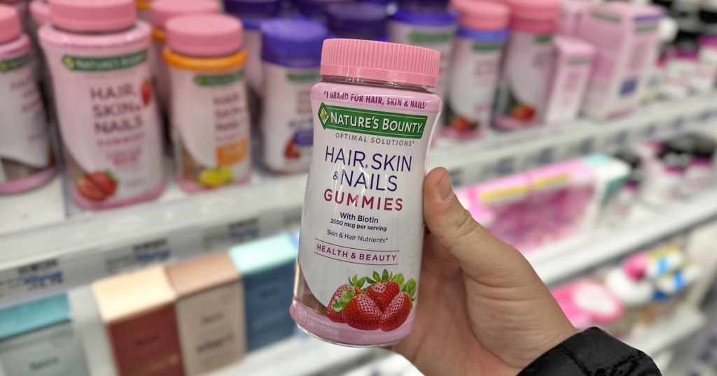 hand holding bottle of Nature's Bounty Optimal Solutions Hair, Skin & Nails Gummies