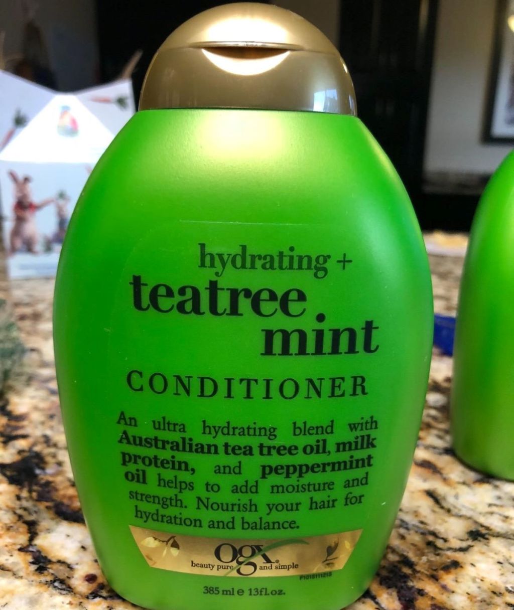 Green bottle of OGX conditioner on a counter