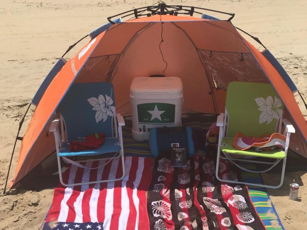 Oileus X-Large 4 Person Beach Tent Sun Shelter with two beach chairs and a cooler inside it 