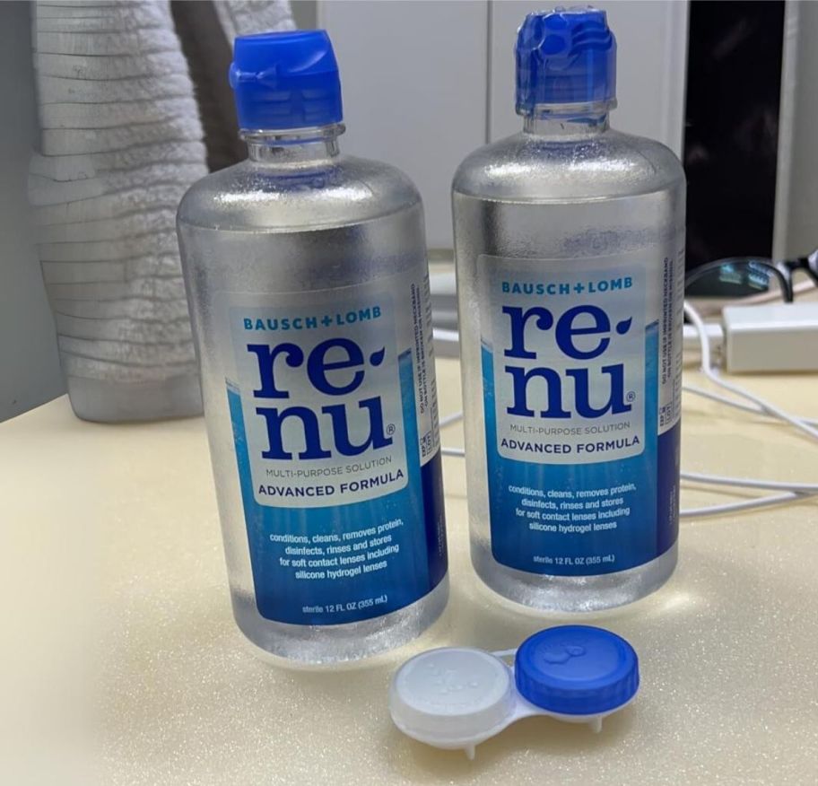 two bottles of contact lens solution on a bathroom counter