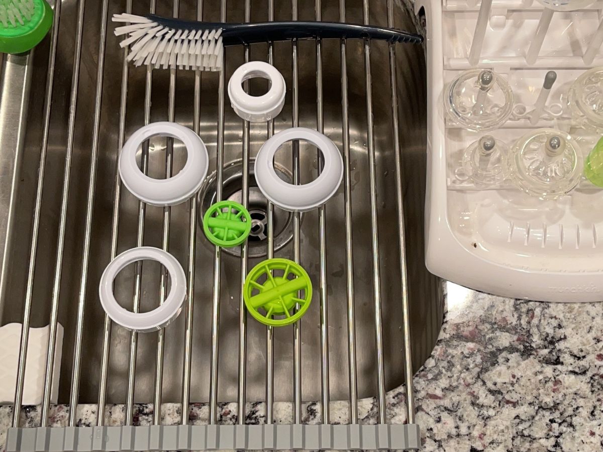 Roll Up Dish Drying rack with baby bottle brush and and bottle parts on it