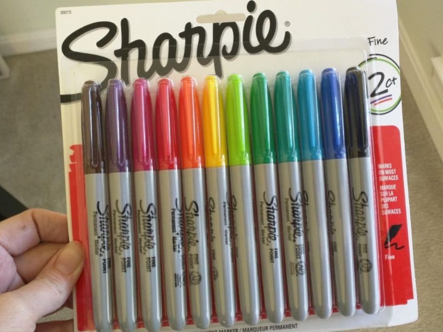Hand holding up a 12-count package of Sharpies in Assorted Colos