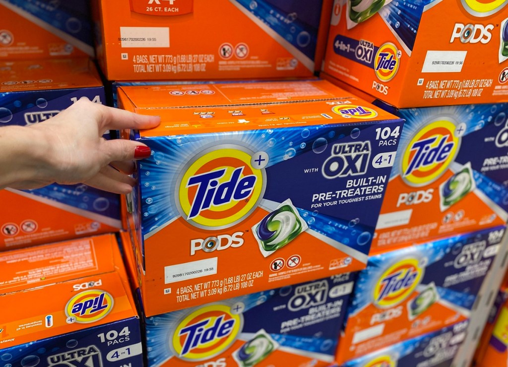 hand holding large box of tide pods on display in store