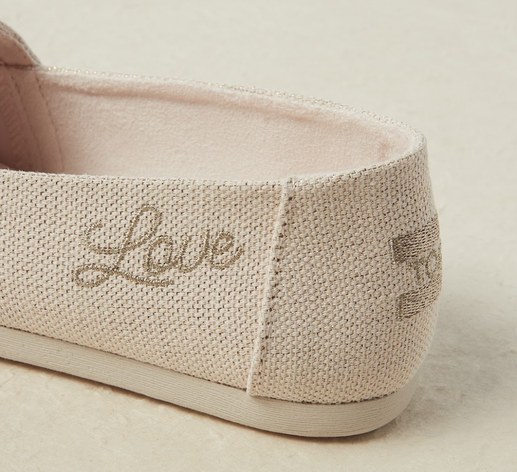 Back of a TOMS shoe that says LOVE