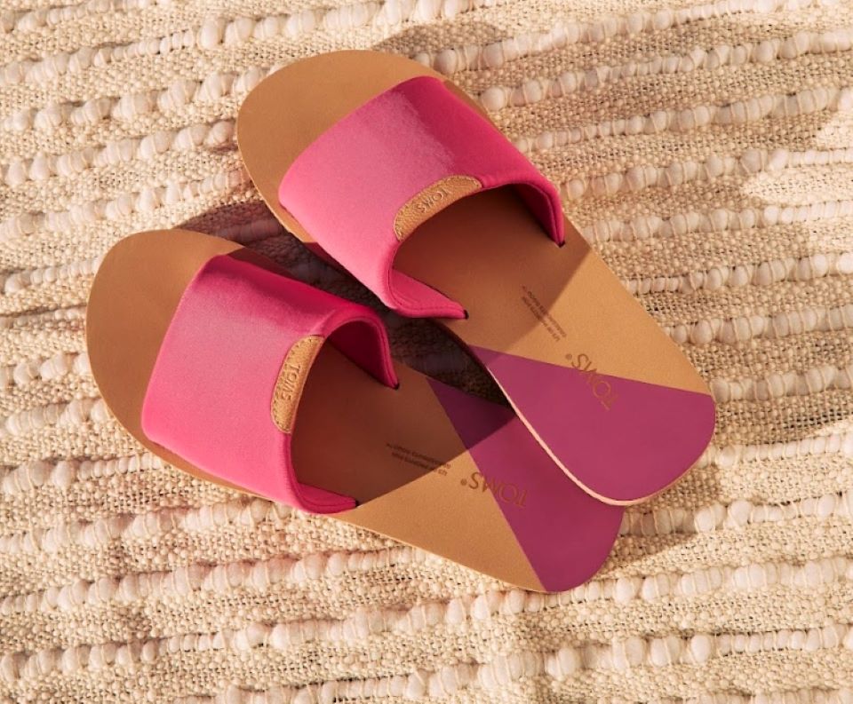 Pair of tan and pink sandals on a blanket