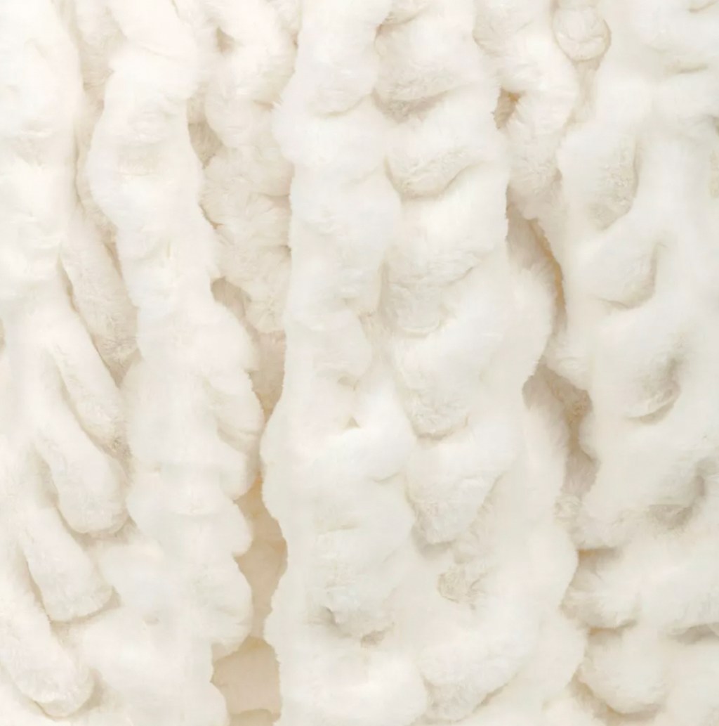 close up of white ruched faux fur throw blanket 