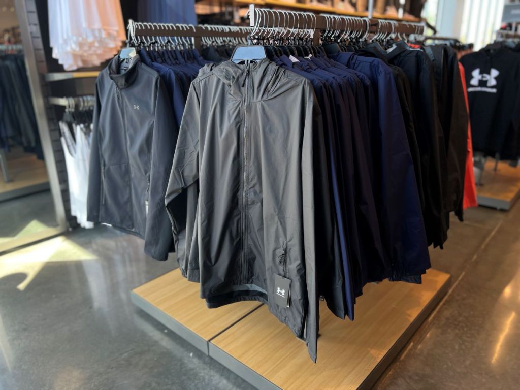 display of Under Armour jackets on hangers at a store