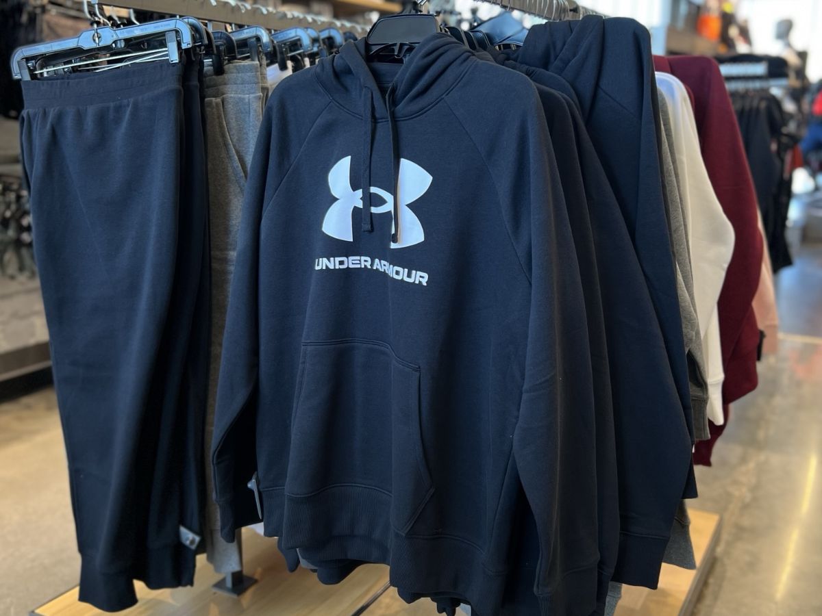 A rack at the store filled with Under armour sweatshirts and joggers.