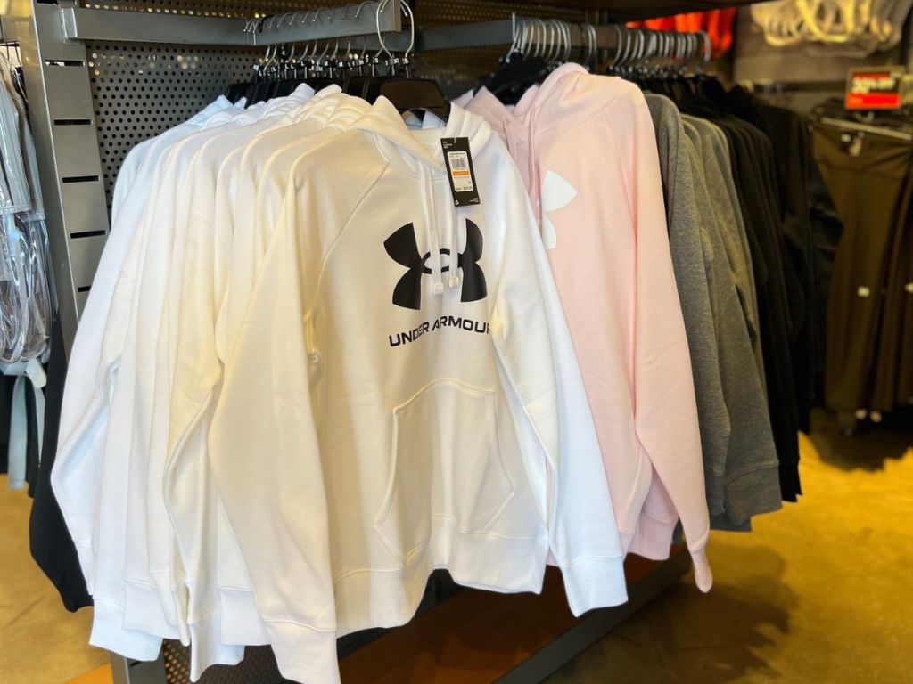 a rack at the store filled with Under Armour Women's Hoddies