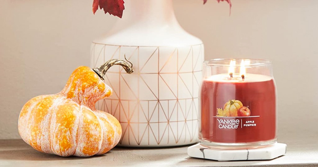 apple pumpkin candle next to gourd