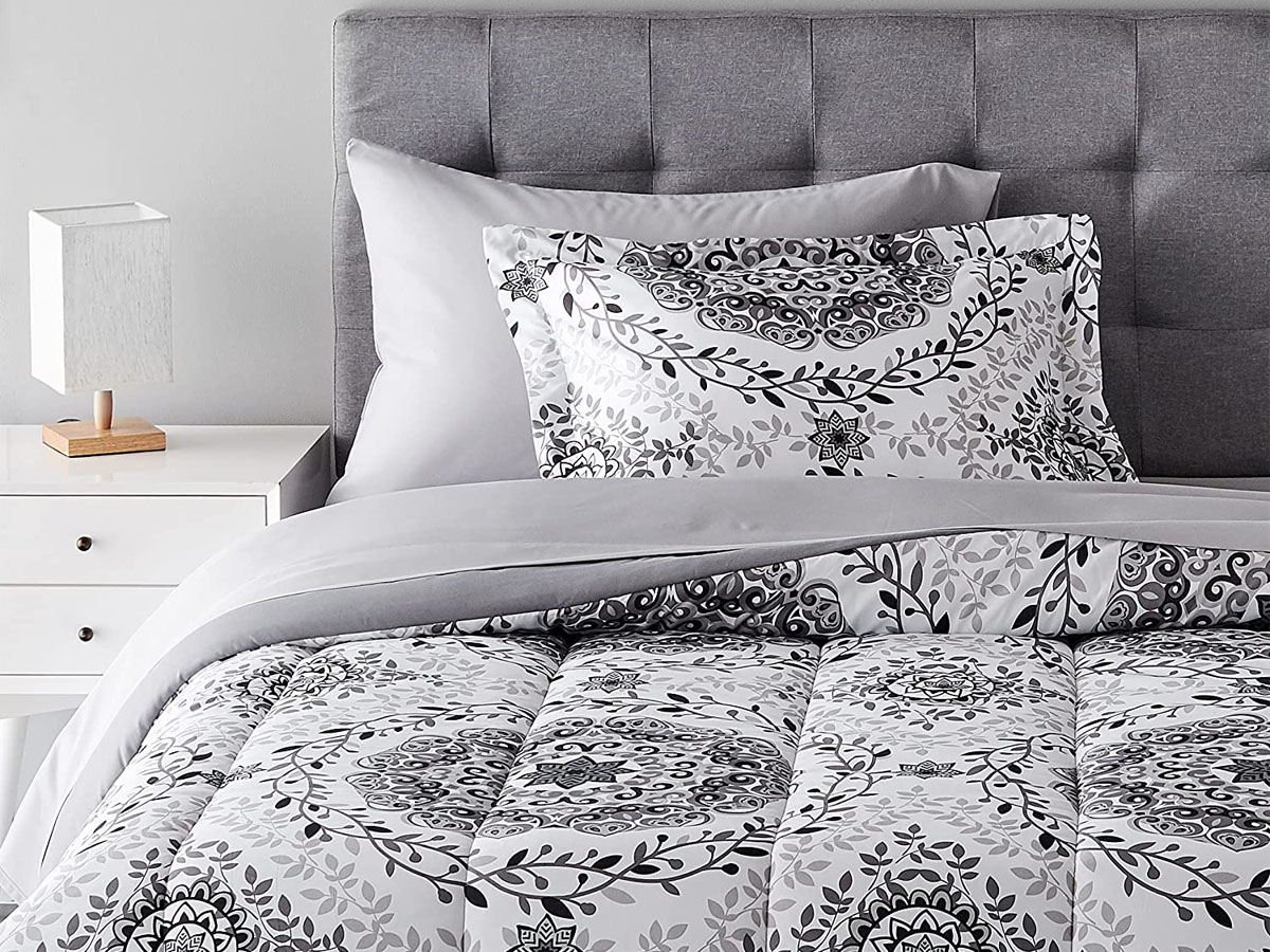 gray and white comforter set on bed