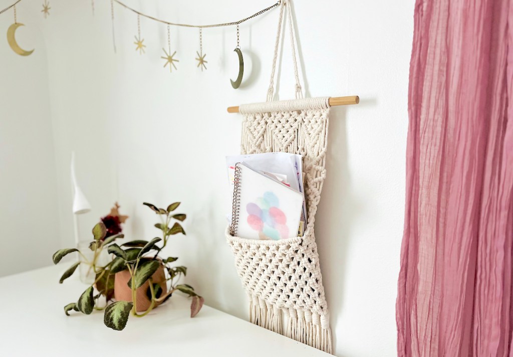 macrame wall hanging above desk with notebook 