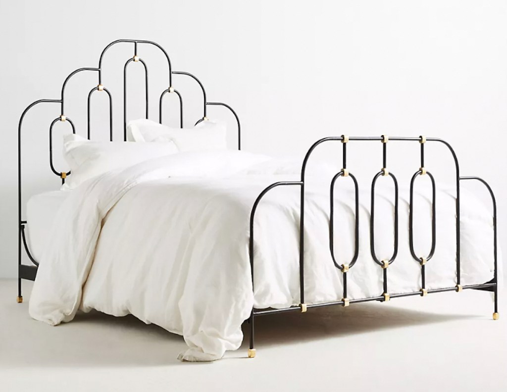 stock photo of black metal bed frame with white bedding 