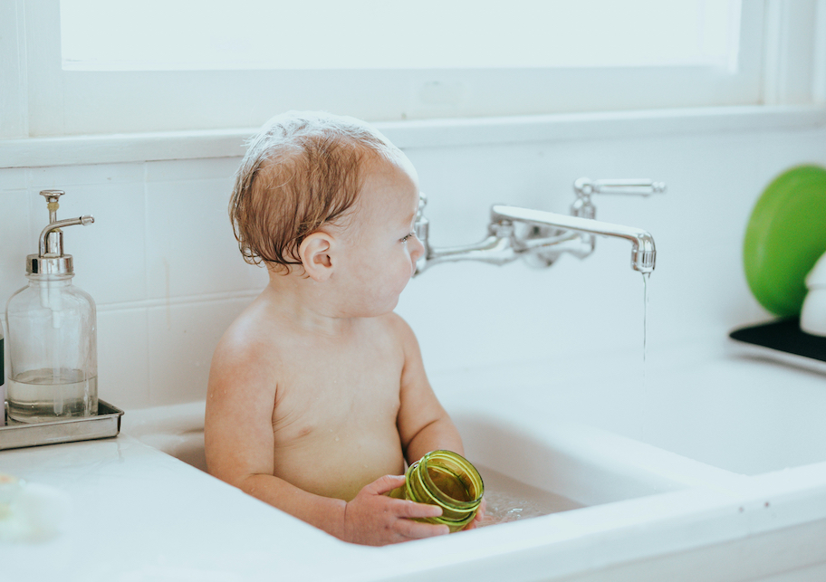 baby in kitchen sink with water