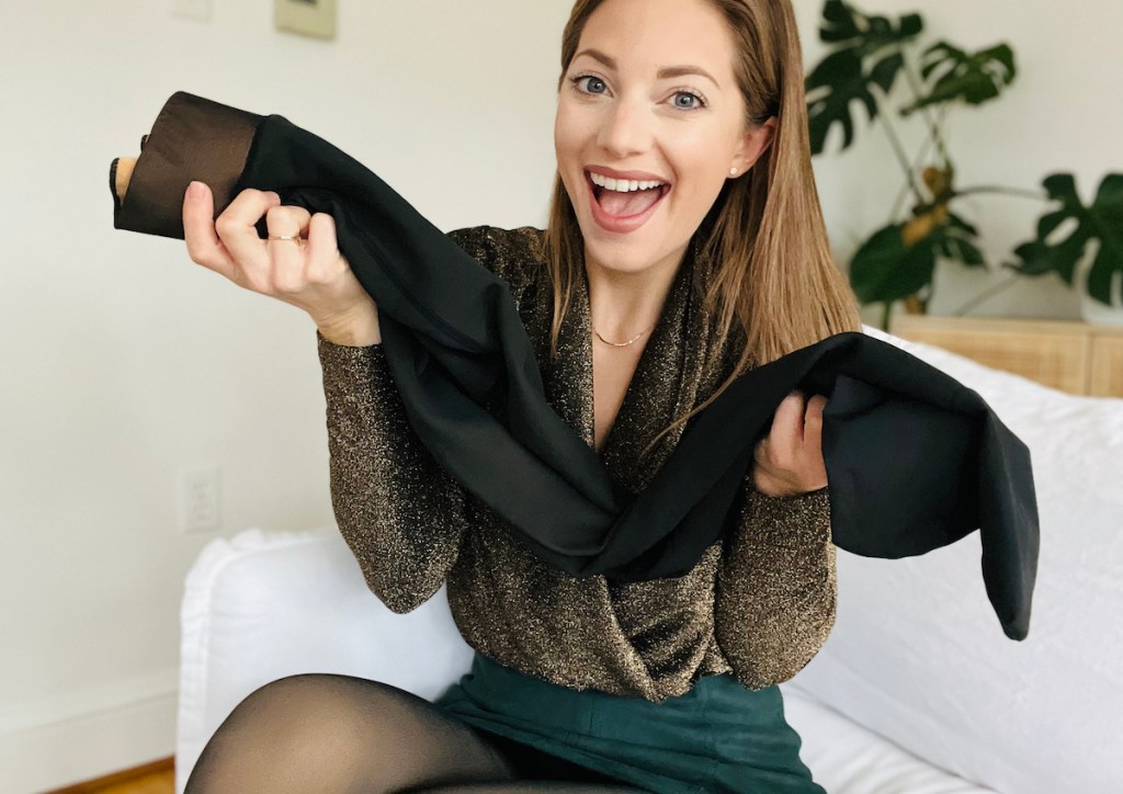 woman holding up black pair of tights
