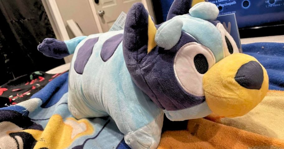 a pillow pet bluey stuffed plush on a bed