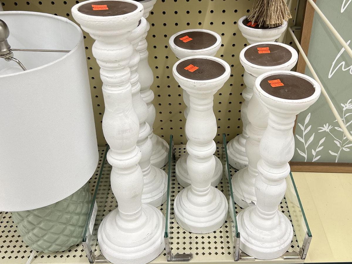 row of white candle holders on shelf