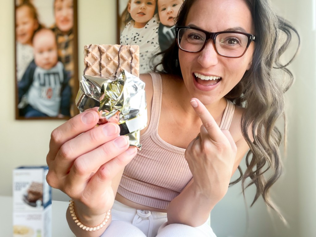 woman pointing at wafer bar in hand