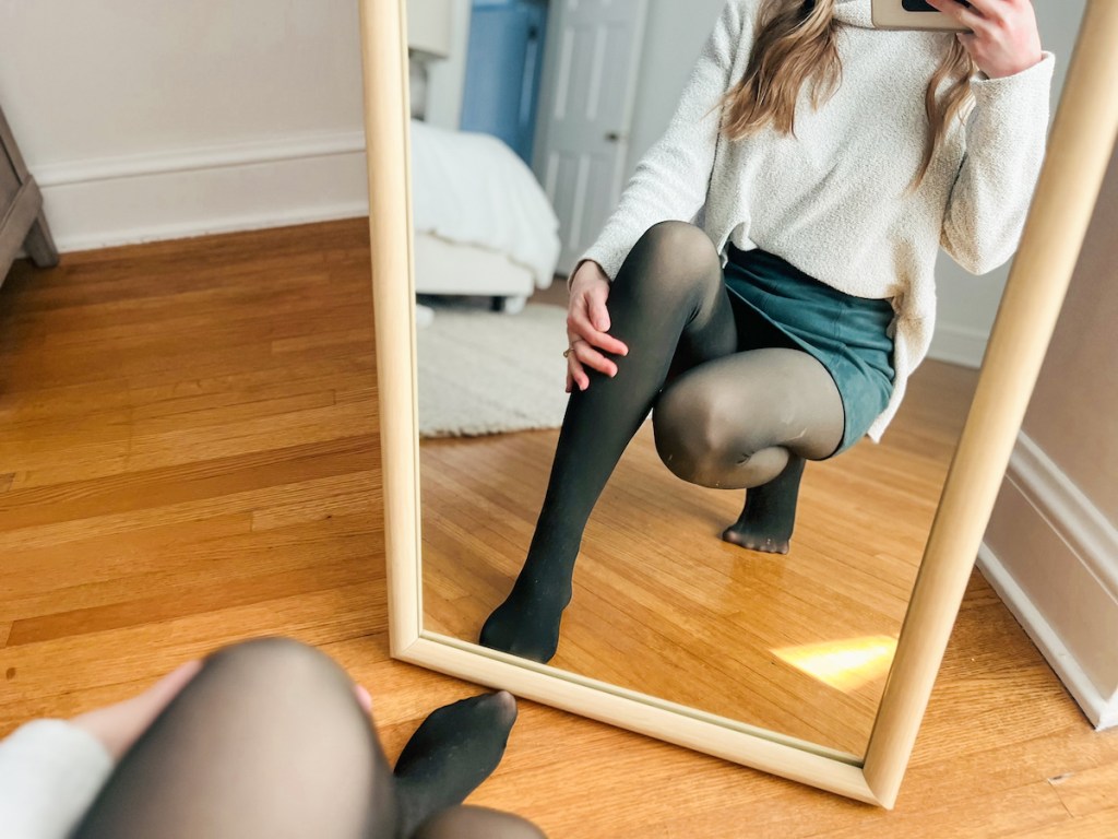 woman taking selfie in mirror wearing black tights