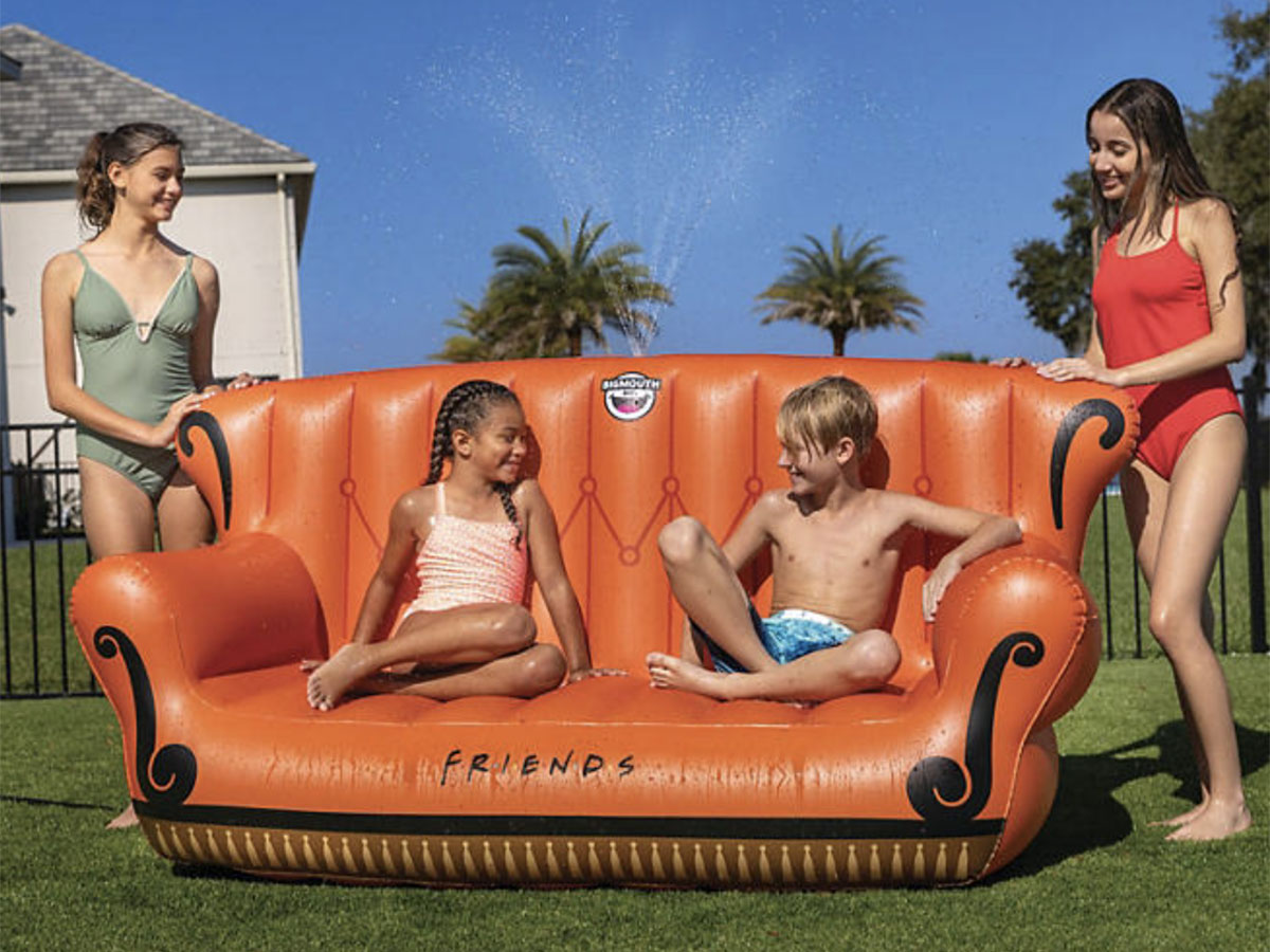 two kids sitting on friends couch spray toy