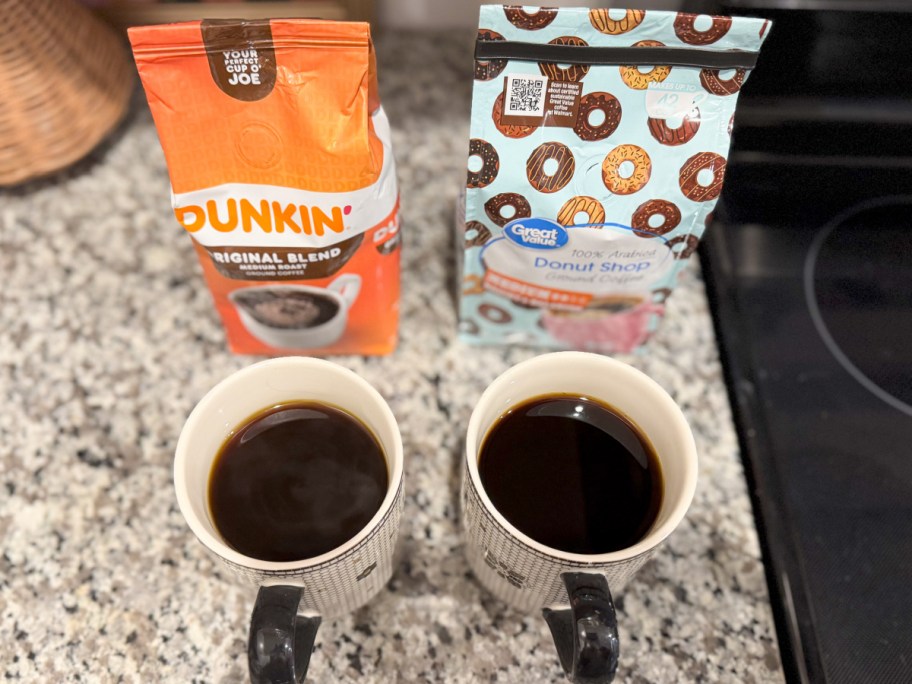 two mugs of coffee in front of coffee bags