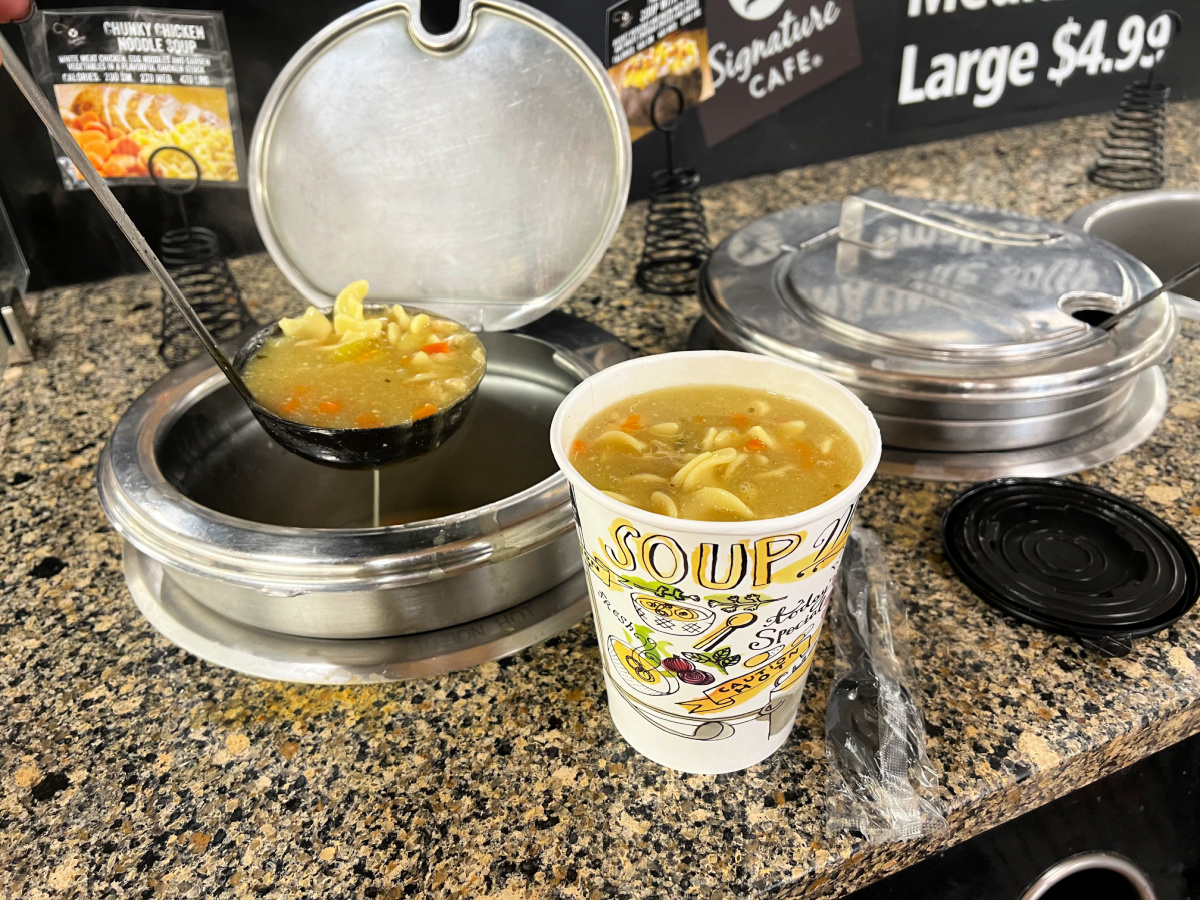 Dishing up chicken noodle soup at a grocery store soup bar for an easy no cook meal idea. 