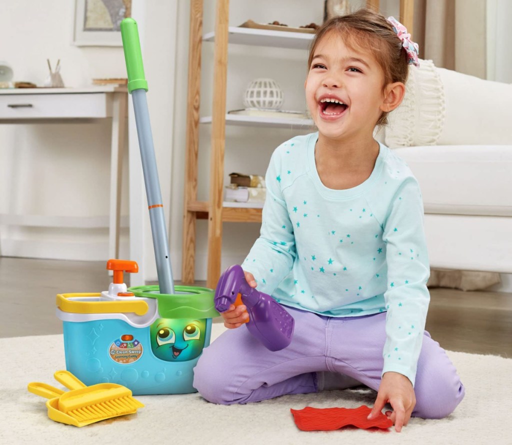 girl laughing and playing with the leapfrog clean sweep learning caddy playset