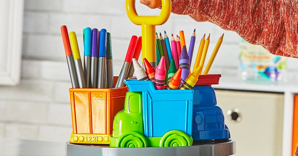 hand holding truck storage caddy with pencils and markers