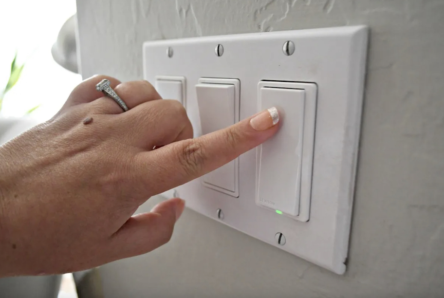 finger pressing light switches on wall